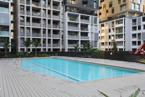 a swimming pool in front of some apartment buildings at 3BR Apt near Stadiums, Family-Friendly, Cozy decor in Sydney