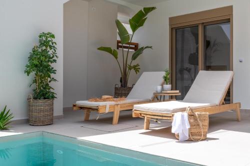 un patio con 2 tumbonas y una piscina en Mariann Premium Suites, en Lardos