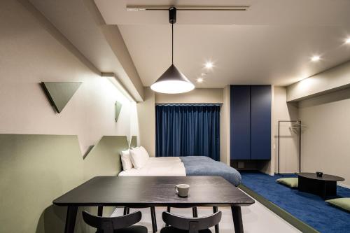 - une chambre avec un lit, une table et des chaises dans l'établissement Section L Kuramae - Asakusa, à Tokyo