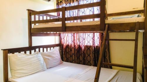 a bedroom with two bunk beds with white pillows at Kara's Condotels in Cebu City