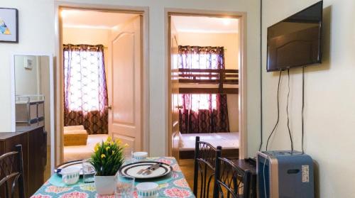 a dining room with a table and a television in a room at Kara's Condotels in Cebu City