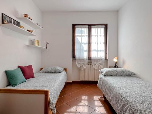 a bedroom with two beds and a window at Casetta nel verde in Varazze