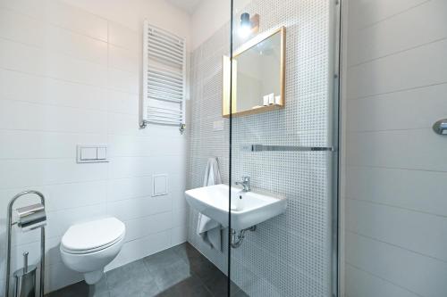 biała łazienka z umywalką i toaletą w obiekcie A&J Studios Mostowa Old Town w Poznaniu
