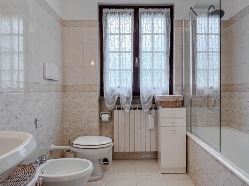 a bathroom with a toilet and a sink and a tub at Casetta nel verde in Varazze