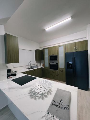 a kitchen with a black refrigerator and a counter at Oasi Rejuve Villa in Meneou