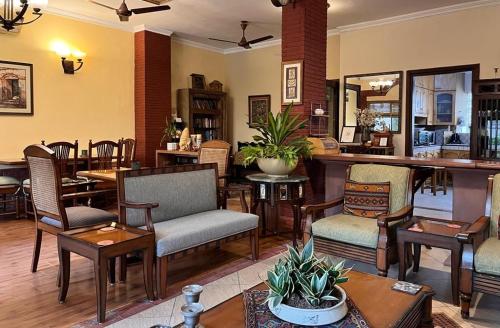 a restaurant with chairs and tables and a bar at The Estate Villa in New Delhi