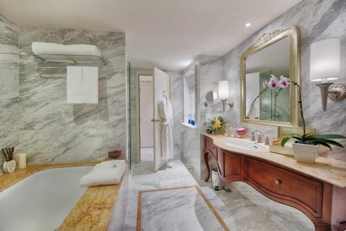 a bathroom with a tub and a sink and a mirror at Apricot Hotel in Hanoi