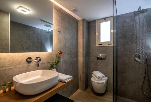 La salle de bains est pourvue d'un lavabo, d'une douche et de toilettes. dans l'établissement Beachfront Blue apt-Ligaria beach, à Ligaria