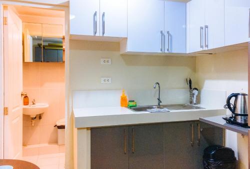 a kitchen with white cabinets and a sink at Kara's Condotels in Cebu City