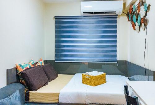 a bedroom with a bed with a blue window at Kara's Condotels in Cebu City