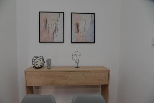 a wooden desk with two pictures on the wall at Dino & Gorge Apartments in Gevgelija