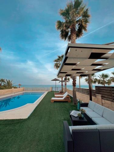 a backyard with a swimming pool and a white umbrella at Oasi Rejuve Villa in Meneou