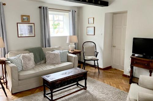 a living room with a couch and a tv at Box Cottage in Broadway