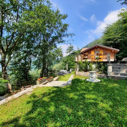 Esino Lario的住宿－Chalet Grigna - Your Mountain Holiday，田野中的房屋,有房子的院子
