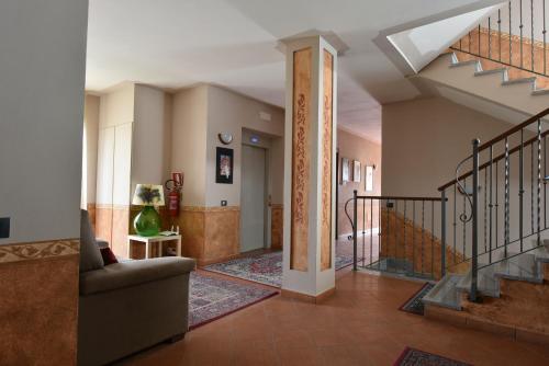 a living room with a staircase and a couch at Hotel Ristorante Borgovecchio in Montegrosso dʼAsti