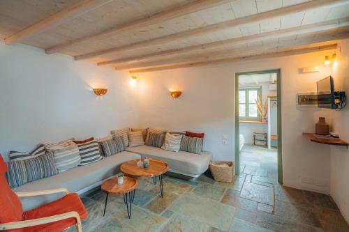 a living room with a couch and two tables at Houses at Chrisopigi Sifnos in Chrisopigi