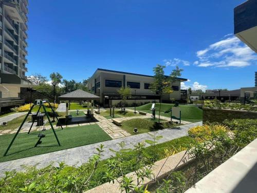 einen Garten mit einem Spielplatz und einem Gebäude in der Unterkunft Verdon Parc Condominium in Davao City