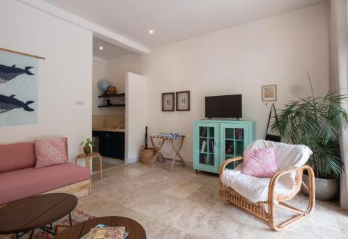 a living room with a couch and a tv at Kresna By The Sea By Kresna Hospitality in Seminyak
