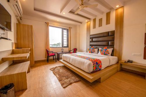 a bedroom with a bed and a desk and a window at FabHotel AS Residency in Dehradun