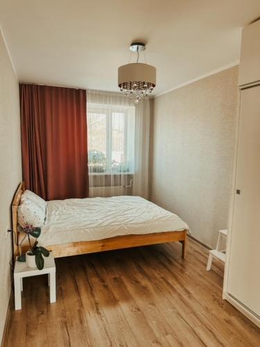 1 dormitorio con 1 cama en una habitación con ventana en Middle street apartment, en Alūksne