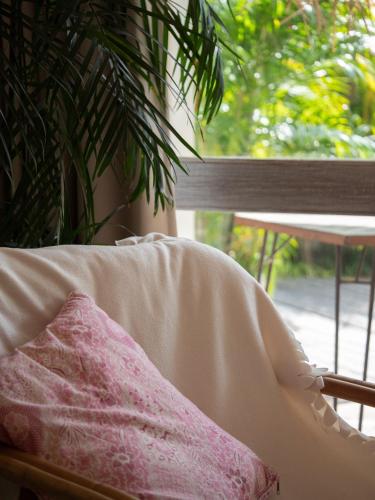 a pillow sitting on a chair next to a window at Kresna By The Sea By Kresna Hospitality in Seminyak