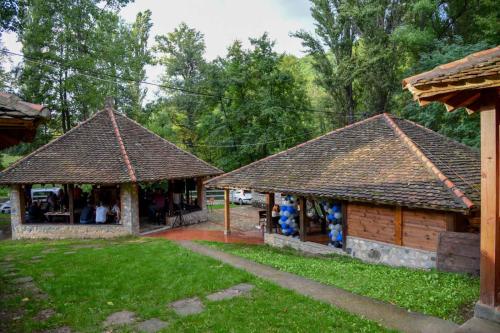 two small buildings with roofs on top of a yard at Poljoprivredno turističko domaćinstvo Degurić in Valjevo