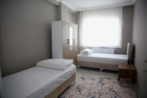 a small room with two beds and a window at Araklı Residence in Araklı