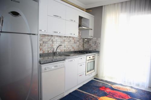 cocina con armarios blancos y nevera en Araklı Residence, en Araklı