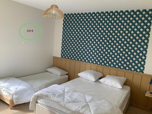 zwei Betten in einem Zimmer mit einem grünen Kreis an der Wand in der Unterkunft Ti-roue in Saint-Gildas-de-Rhuys