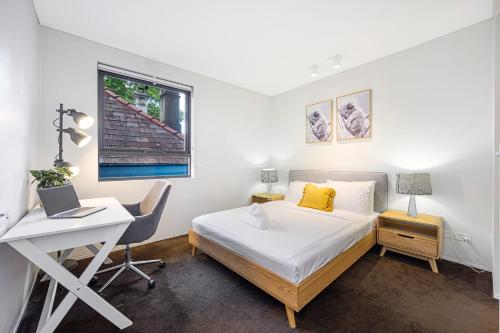um quarto com uma cama, uma secretária e um computador portátil em Comfy 2BD Apt in heart of North Sydney near by CBD em Sydney