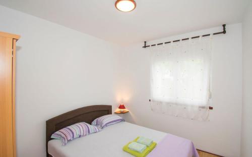 a bedroom with a bed with two pillows and a window at Apartman V in Premantura near the center of town in Premantura