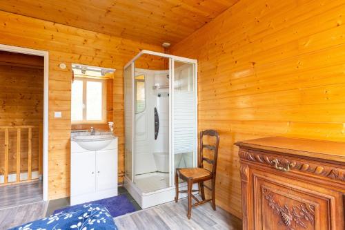 a bathroom with a shower and a sink and a chair at Gite Du Dombief in La Chaux-du-Dombief