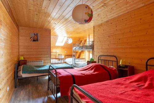 a bedroom with two beds in a wooden room at Gite Du Dombief in La Chaux-du-Dombief