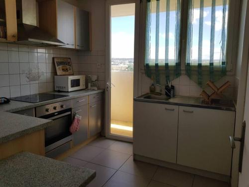 een keuken met een fornuis en een magnetron bij Appart 6 pers Marignane à 5 min -plage et aéroport in Marignane