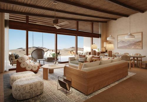 uma sala de estar cheia de mobiliário e uma grande janela em Six Senses Southern Dunes, The Red Sea 
