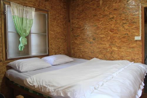 a bed with two pillows in a room with a window at Rangbondoi - Birdwatching Included 