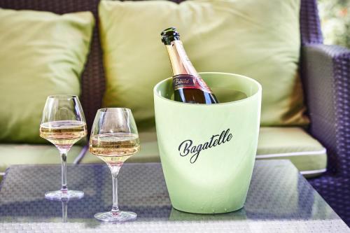 a bottle of wine in a bucket next to two wine glasses at Logis Bagatelle - 51530 Dizy in Épernay