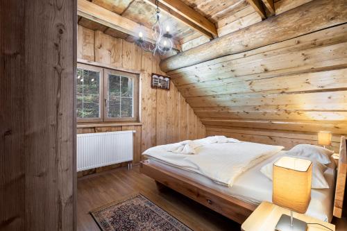 a wooden bedroom with a bed in a room at Chalet Durik Bystra - Jacuzzi - Sauna - In the forest - 10 min walk to restaurant - On hiking trail in Horná Lehota