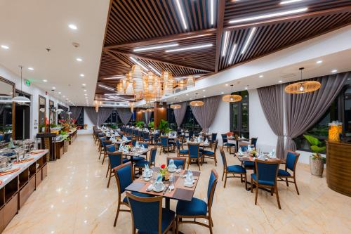 下龍灣的住宿－Hạ Long New Century Hotel，用餐室配有桌椅和吊灯。
