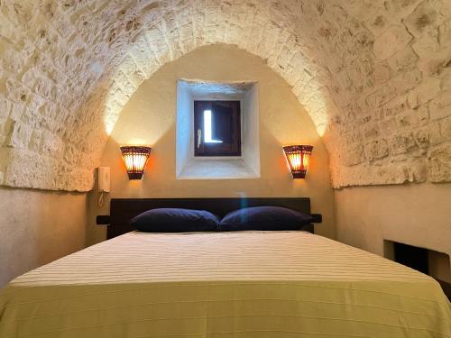 a bedroom with a bed in a stone wall at Casa Vega in Ostuni