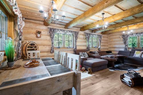 a living room in a log cabin with wooden ceilings at Chalet Durik Bystra - Jacuzzi - Sauna - In the forest - 10 min walk to restaurant - On hiking trail in Horná Lehota