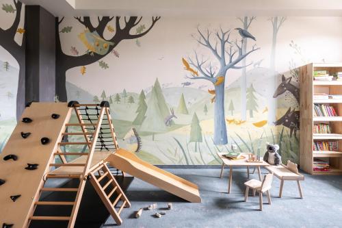 W Dolinie Tylicza في كرينيتسا زدروي: غرفة للأطفال مع جدار غابة