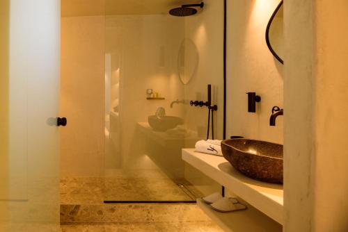 a bathroom with a sink and a toilet and a mirror at LF Suites & Villas in Imerovigli