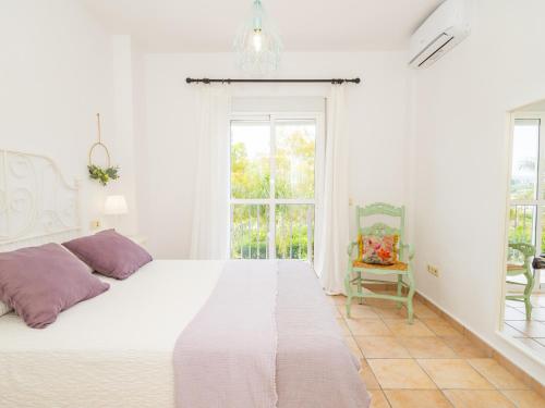 Un dormitorio blanco con una cama grande y una ventana en Cubo's Villa La Quinta, en Alhaurín el Grande
