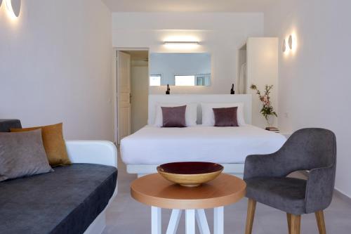 a bedroom with a bed and a couch and a table at Anchor Suites in Oia