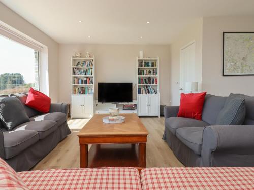 un salon avec deux canapés et une télévision dans l'établissement Hurdwick Lodge, à Tavistock