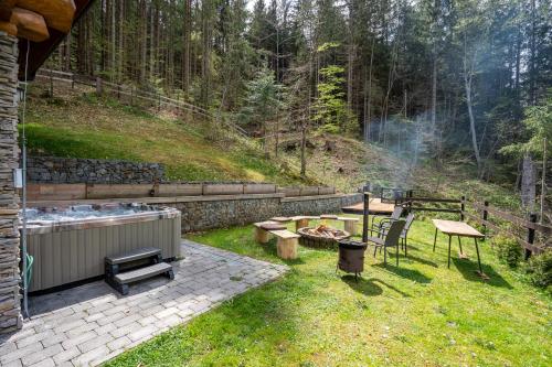 a backyard with a hot tub and a grill at Chalet Durik Bystra - Jacuzzi - Sauna - In the forest - 10 min walk to restaurant - On hiking trail in Horná Lehota