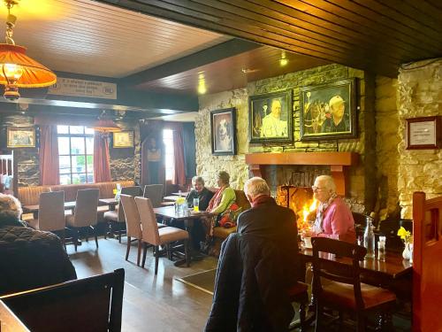 um grupo de pessoas sentadas em mesas em um restaurante em Towers Hotel Glenbeigh em Glenbeigh
