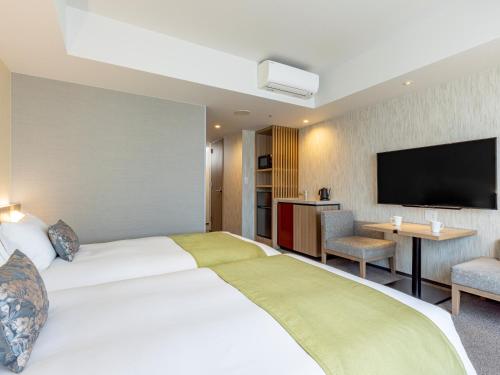 a hotel room with a bed and a flat screen tv at Tokyu Stay Kanazawa in Kanazawa