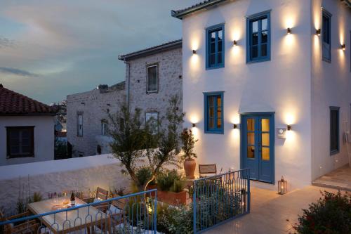 a white house with a blue door at night at Orloff Legacy Suites Hydra in Hydra